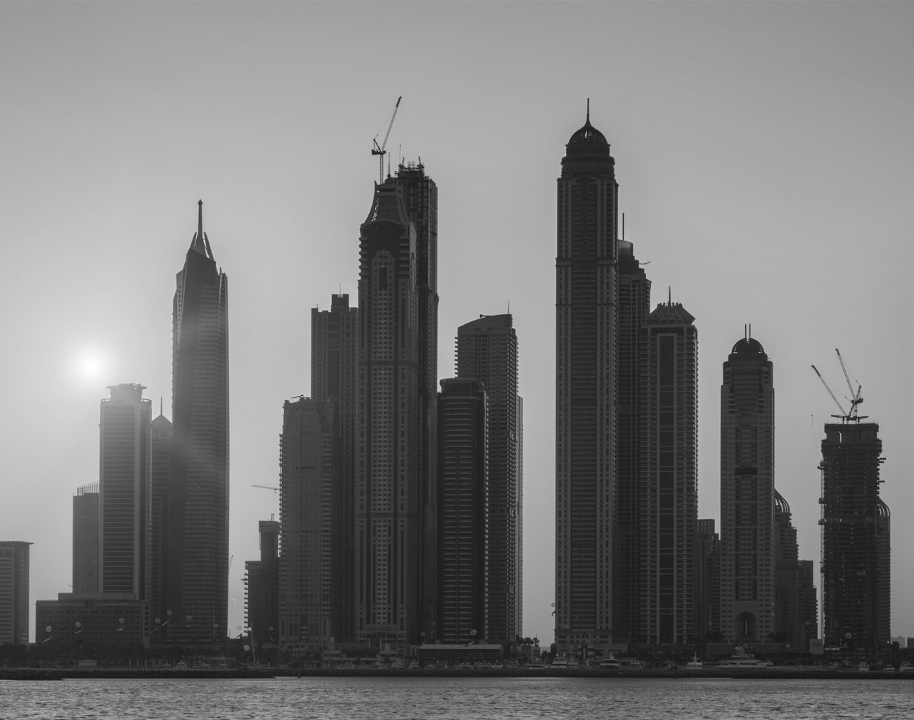 View of Dubai with sun at sunrise, UAE.